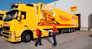 Двое мужчин что-то обсуждают на фоне грузовика DHL