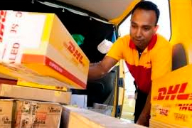 Мужчина выгружает коробки с надписями DHL