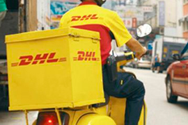 Курьер DHL едет на мотороллере